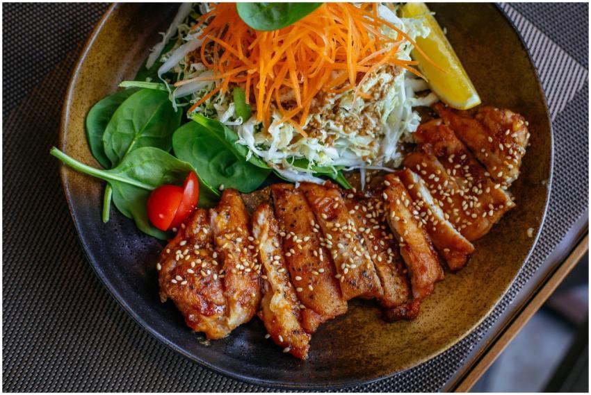 A savory chicken salad bowl garnished with sesame