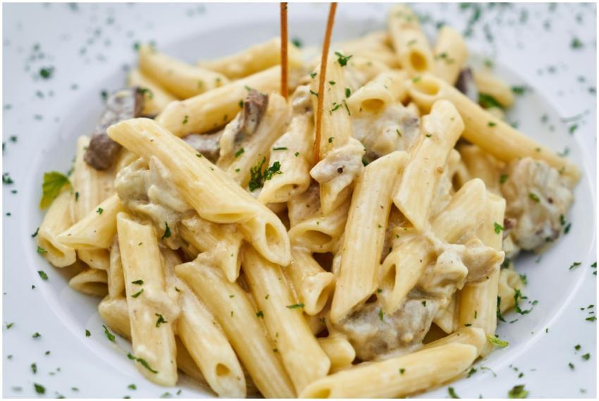 Close-up of creamy pasta with herbs, offering a de
