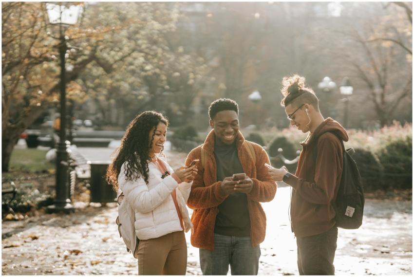 Three diverse young adults enjoying social media t