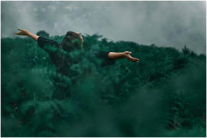 A woman with open arms enjoying freedom in a foggy