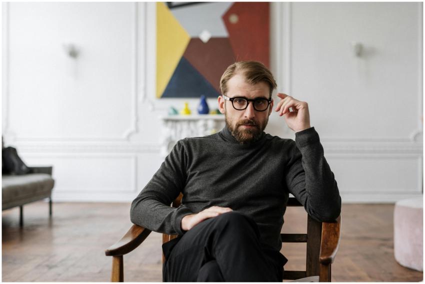 Man with glasses seated in modern interior with ab