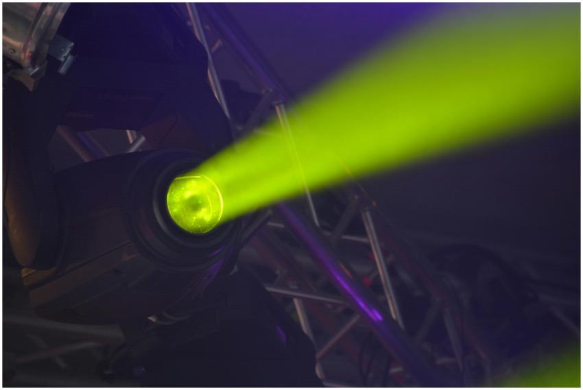 Close-up of a vivid neon spotlight emitting a gree