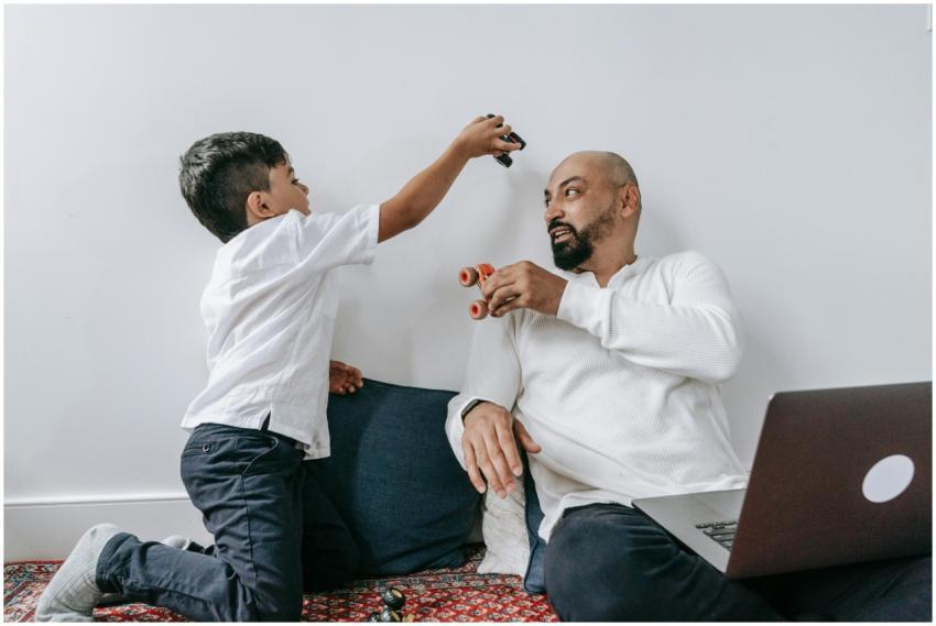 A father and son share a playful moment indoors, e