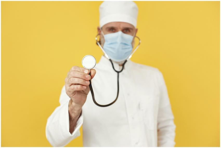 Portrait of a male doctor wearing a face mask, hol