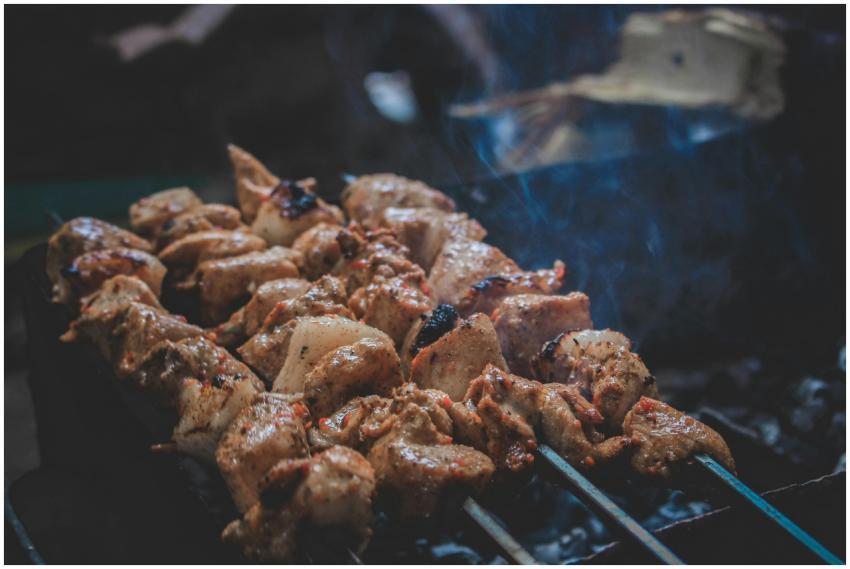 Delicious grilled skewers sizzling on a charcoal g