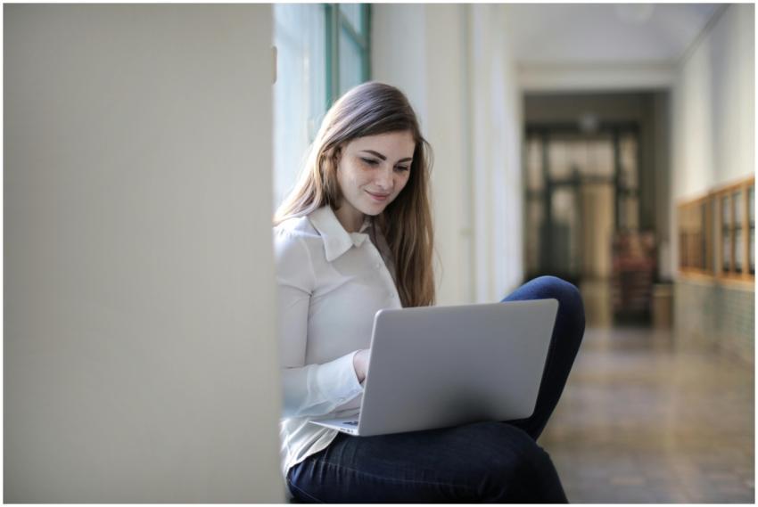 Smiling woman using a laptop indoors, representing