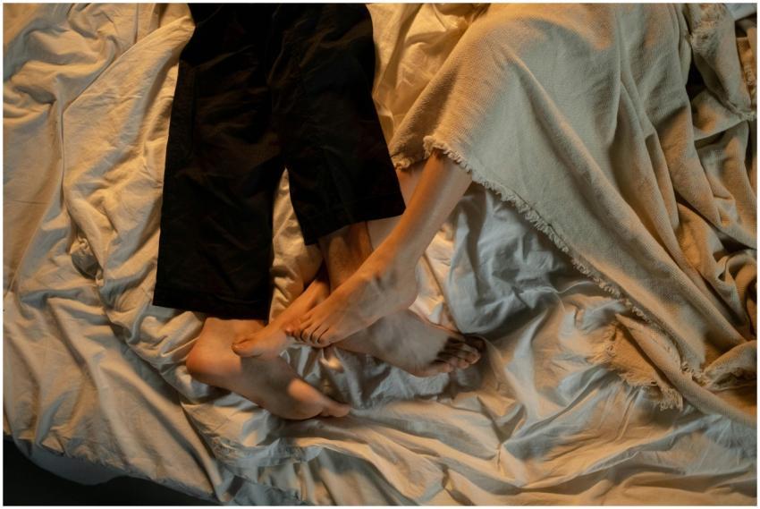 Close-up of a couple's feet intertwined on a cozy