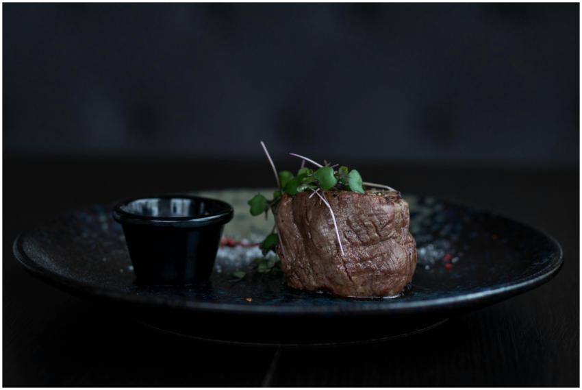 A gourmet beef filet topped with fresh herbs on a