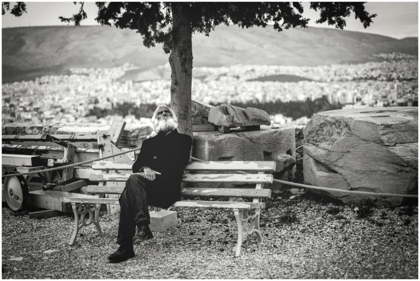 Black and white photo of an elderly man relaxing o