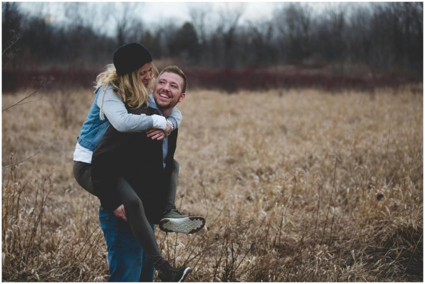 A happy couple enjoys a playful moment in a field