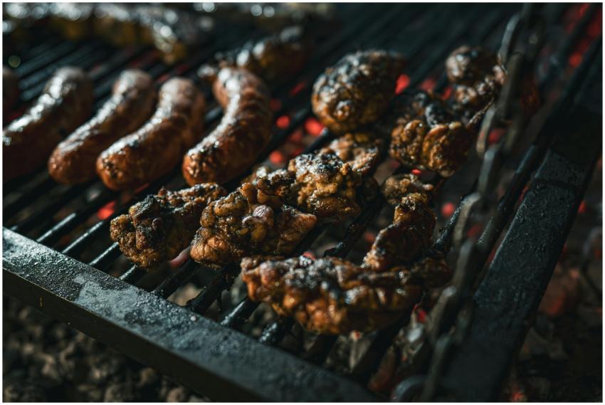 Juicy meats grilling over charcoal, showcasing a t