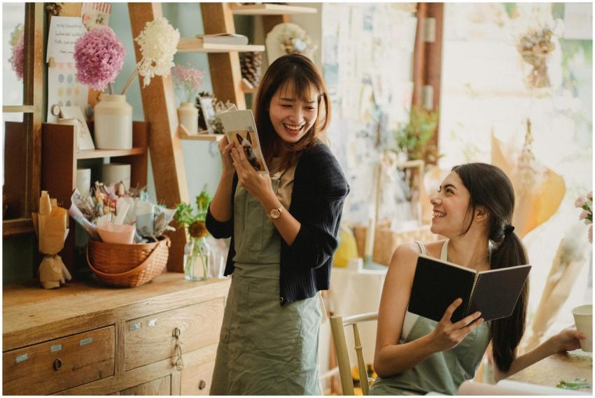 Two women in a floral shop sharing a joyful conver