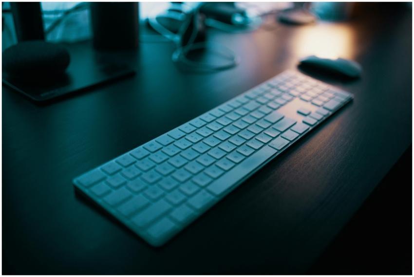 A modern wireless keyboard placed on a sleek desk,