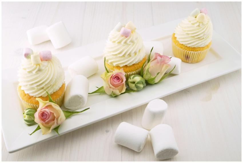 Vanilla cupcakes adorned with roses and fluffy mar