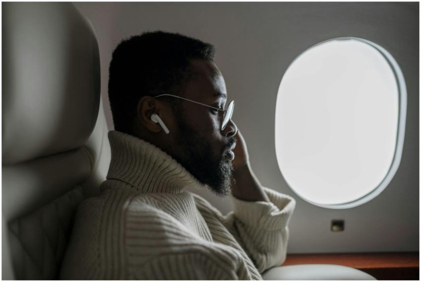 A businessman listening to music on an airplane, s