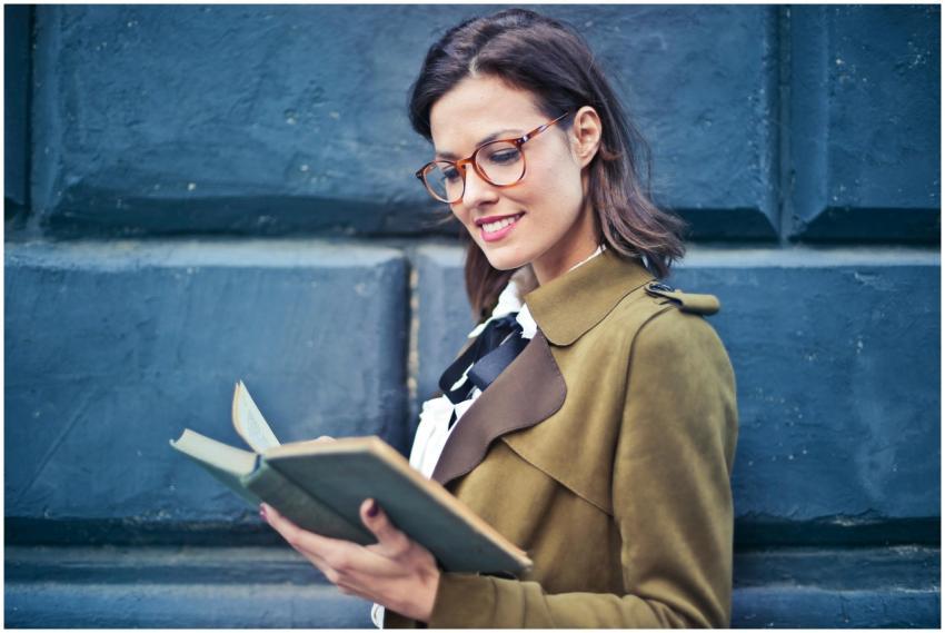 Smiling woman enjoying a book while standing again