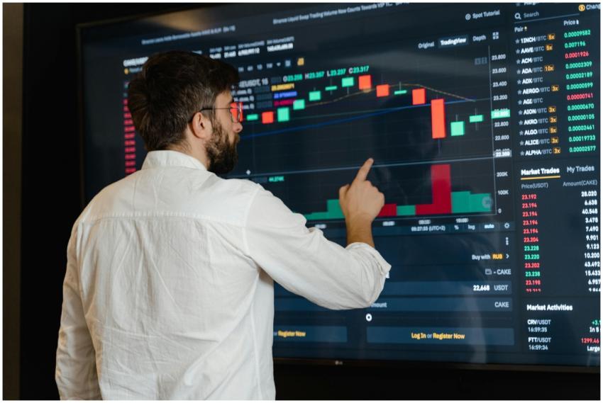 A man analyzes cryptocurrency graphs on a touchscr