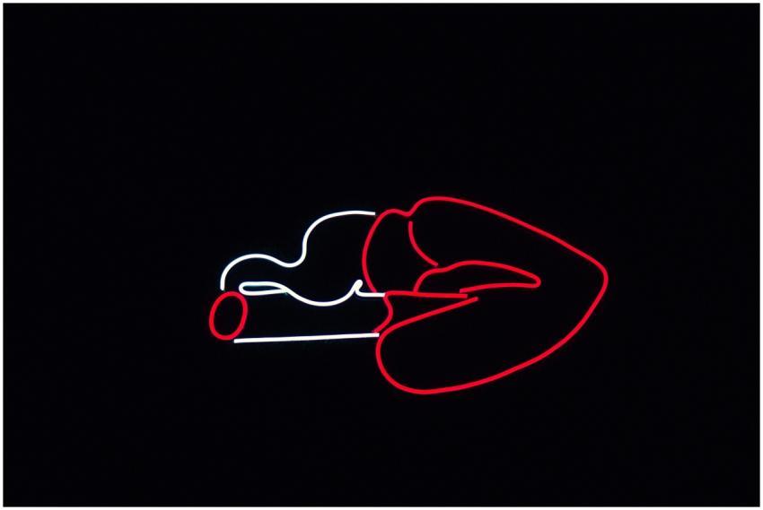 Striking neon sign of lips with a cigarette glowin