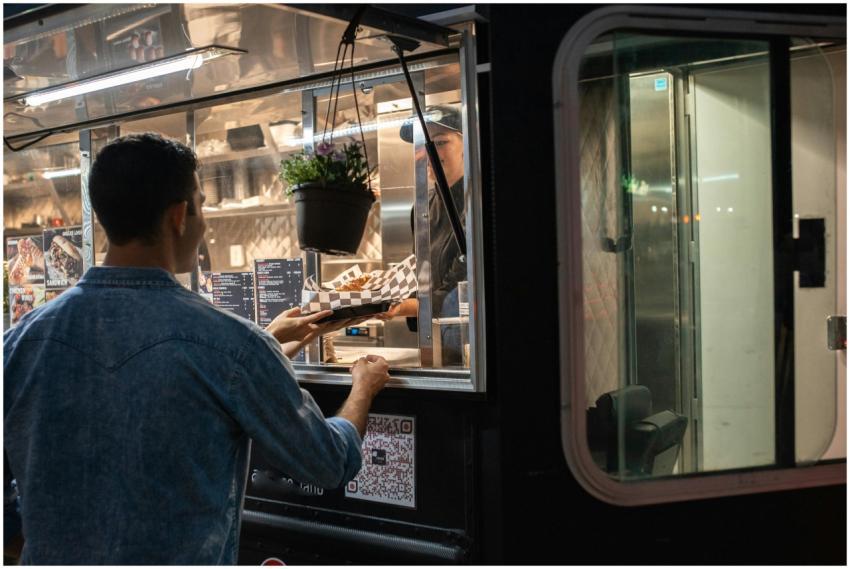 A man orders food from a food truck at night, show