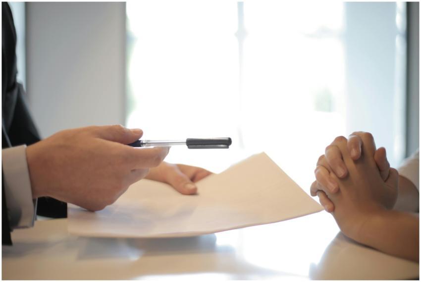 Close-up of a contract signing with hands over doc