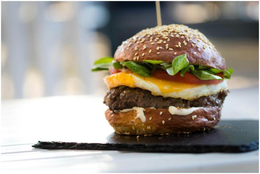 Close-up of a gourmet cheeseburger with spinach an