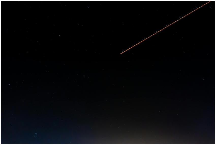 A serene night sky with a shooting star and numero