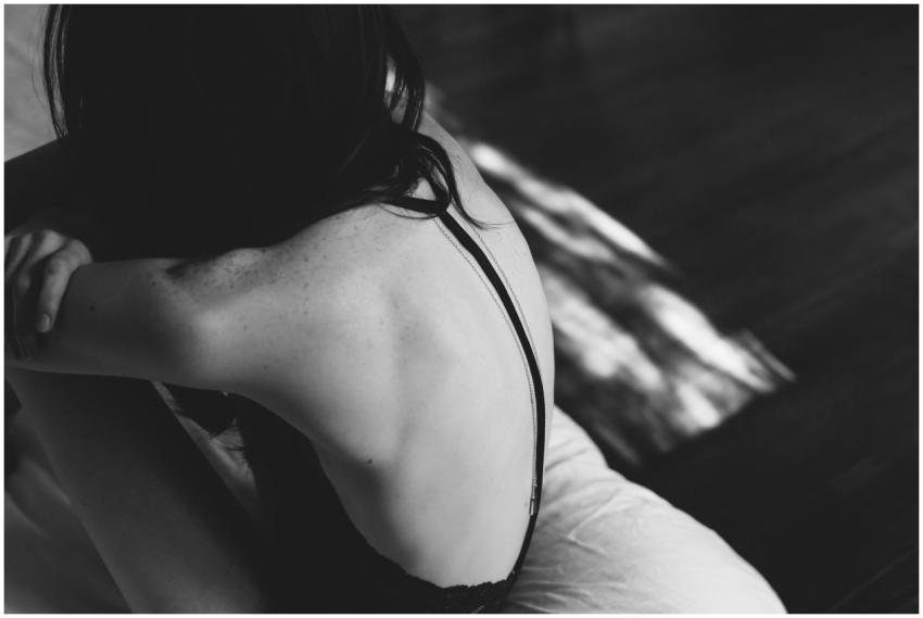 An artistic black and white portrait of a woman fr