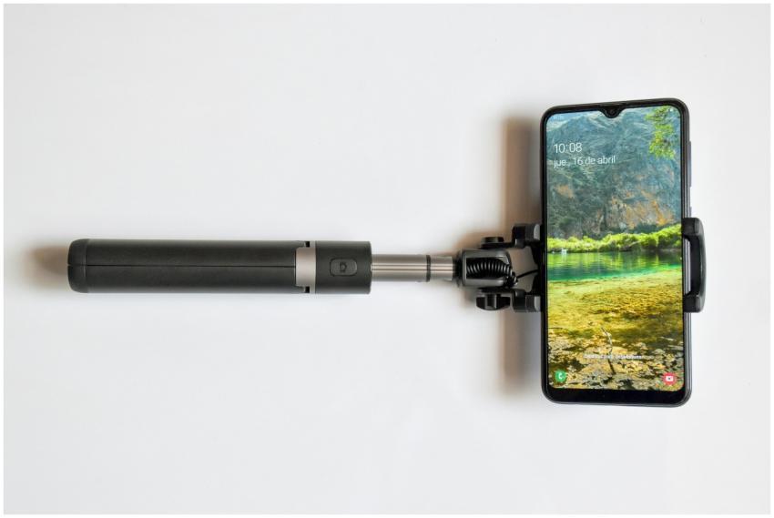Modern smartphone mounted on a selfie stick agains
