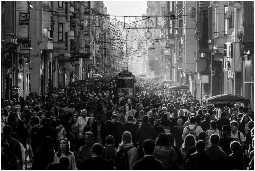 A vibrant, crowded street scene featuring a tram s