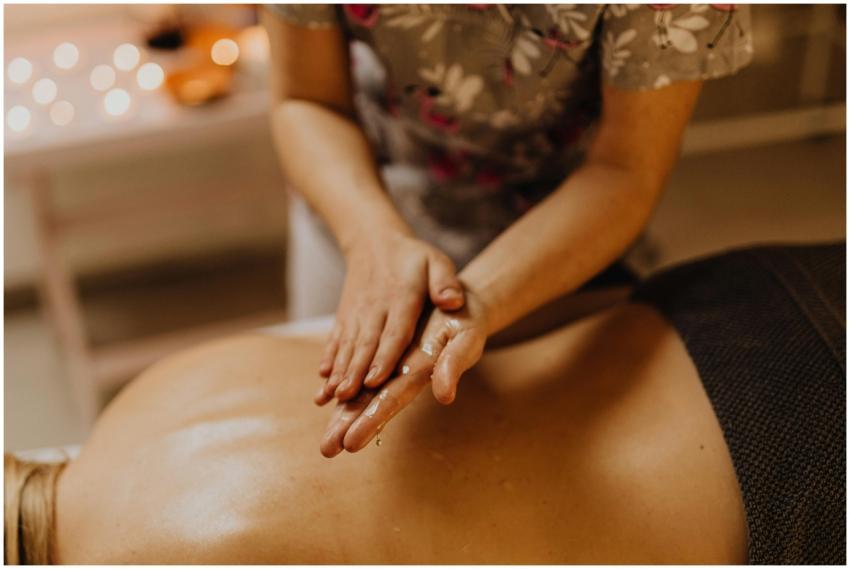 Hands massaging a person's oiled back in a calming