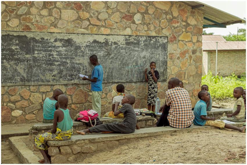 Children studying outdoors with a teacher, engagin