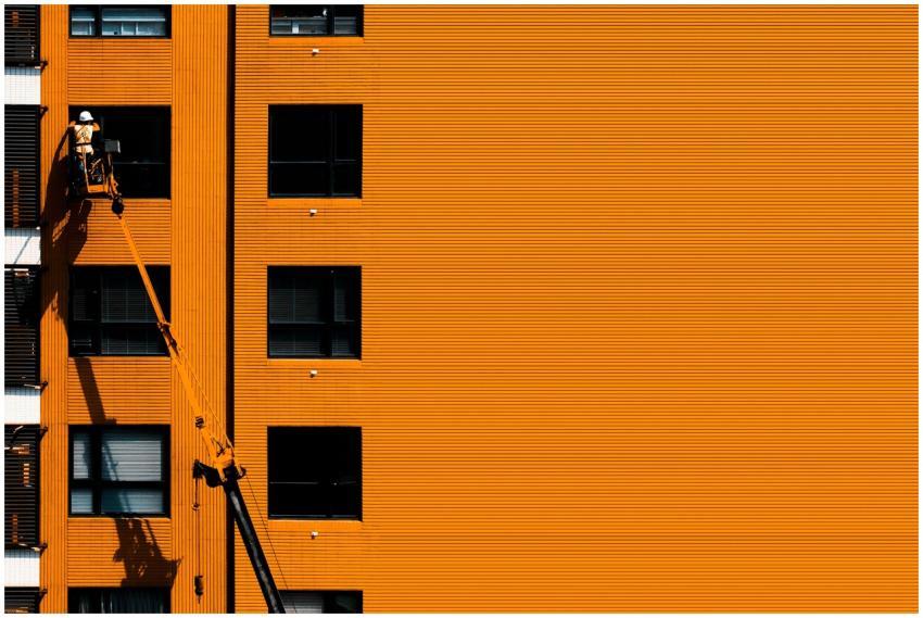 A construction worker using a cherry picker workin