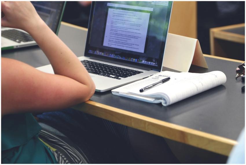 A student in a classroom setting using a laptop an