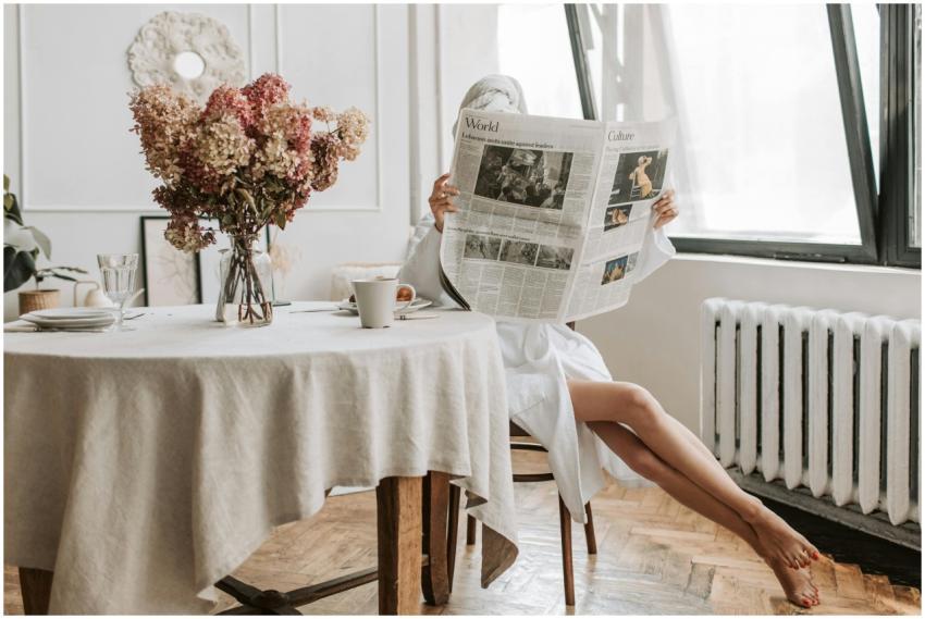Woman enjoying a relaxing morning, reading a newsp