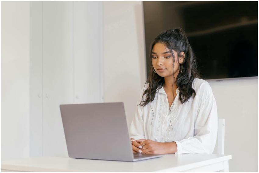 A young woman focused on studying with her laptop