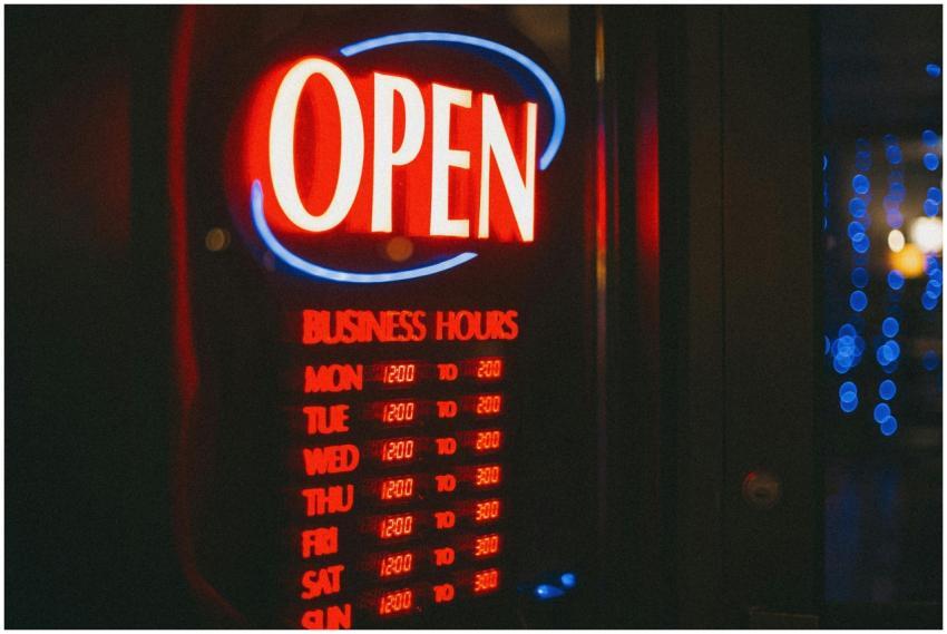 Bright neon open sign displaying business hours, g