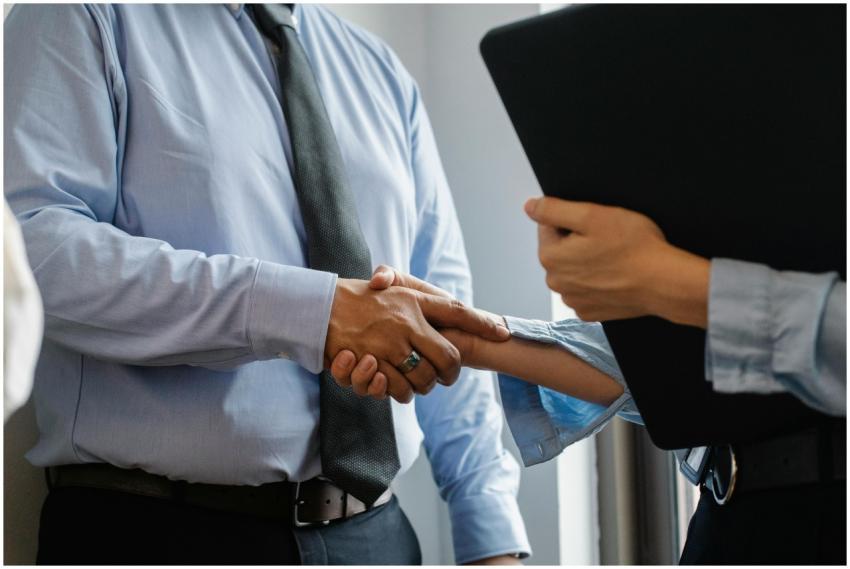 Crop anonymous man in formal shirt and tie shaking