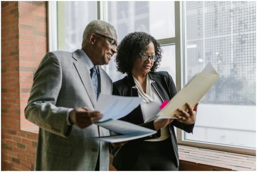 Two business professionals discussing documents wi