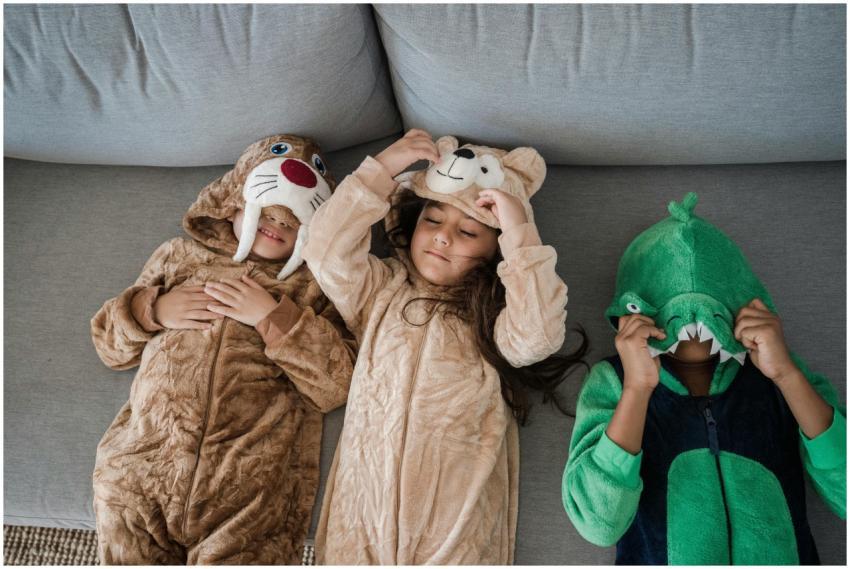 Three kids wearing animal costumes playing togethe