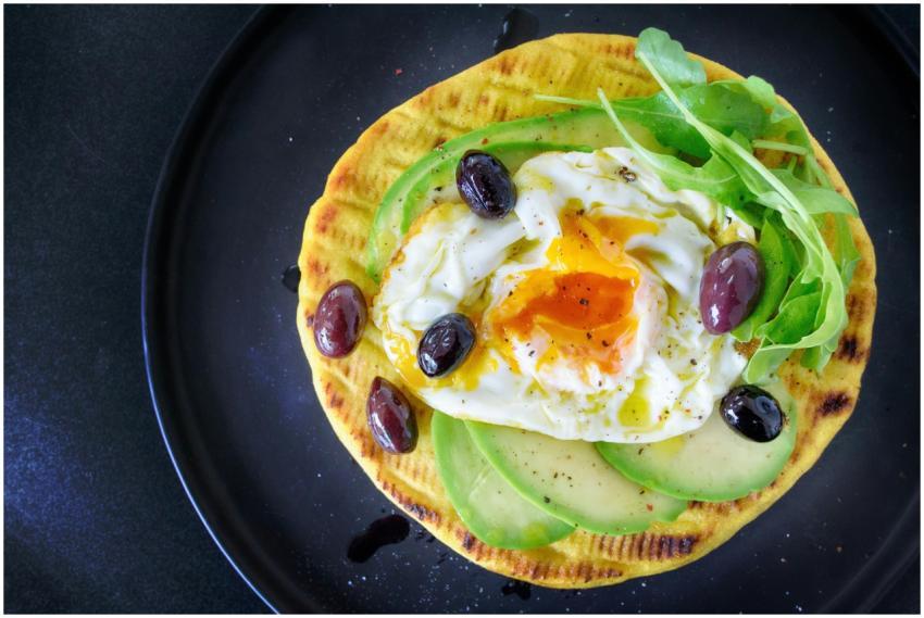 Delicious flatbread topped with avocado, egg, arug