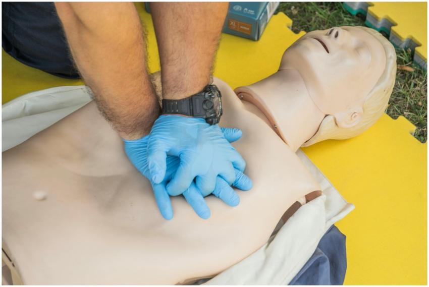 Close-up of hands performing CPR on a manikin for