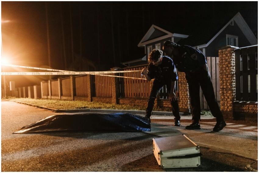 Police officers investigate a crime scene at night