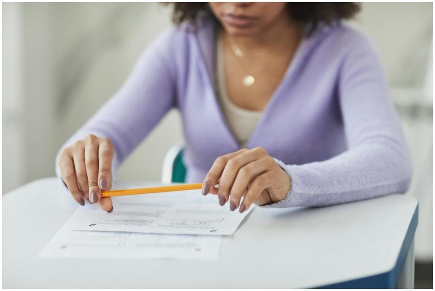 A focused student in a classroom setting, holding