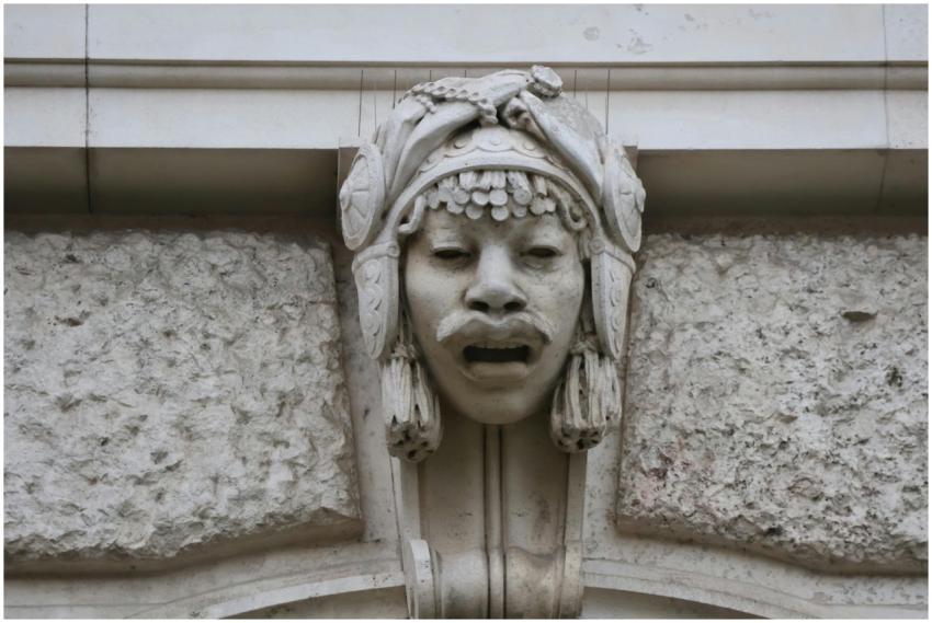 Intricate stone face sculpture on a historic build