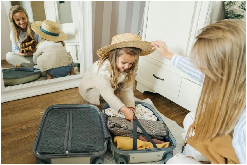 A mother and daughter pack a suitcase for a summer
