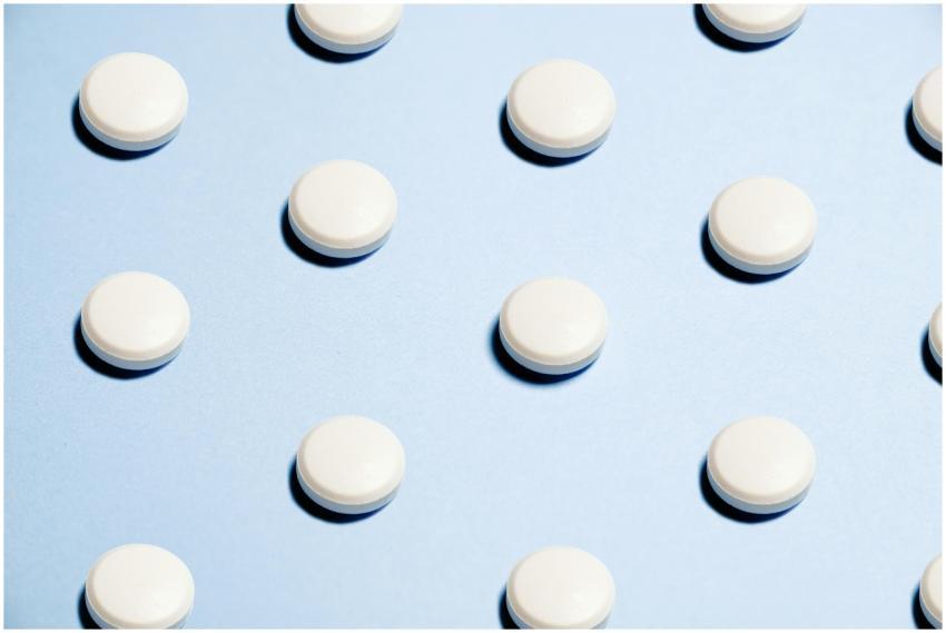 Array of white pills on a light blue background, i