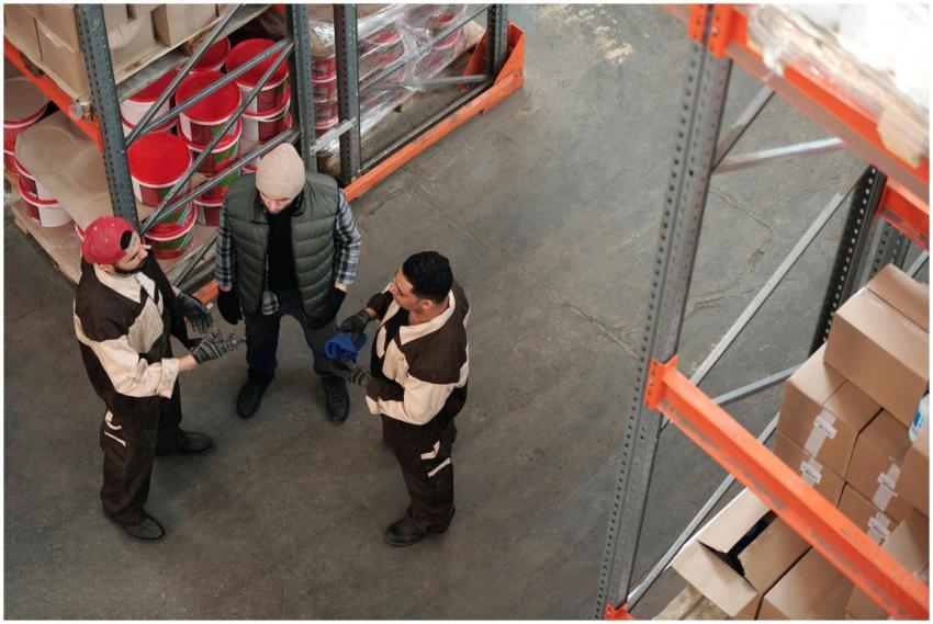 Three workers discussing logistics in an industria