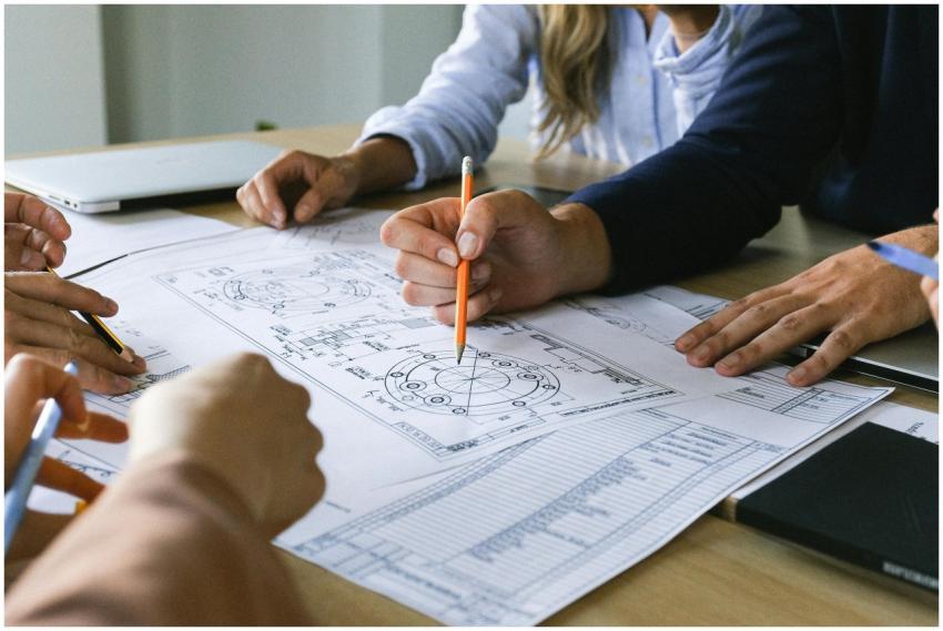 Team working on engineering plans, discussing idea