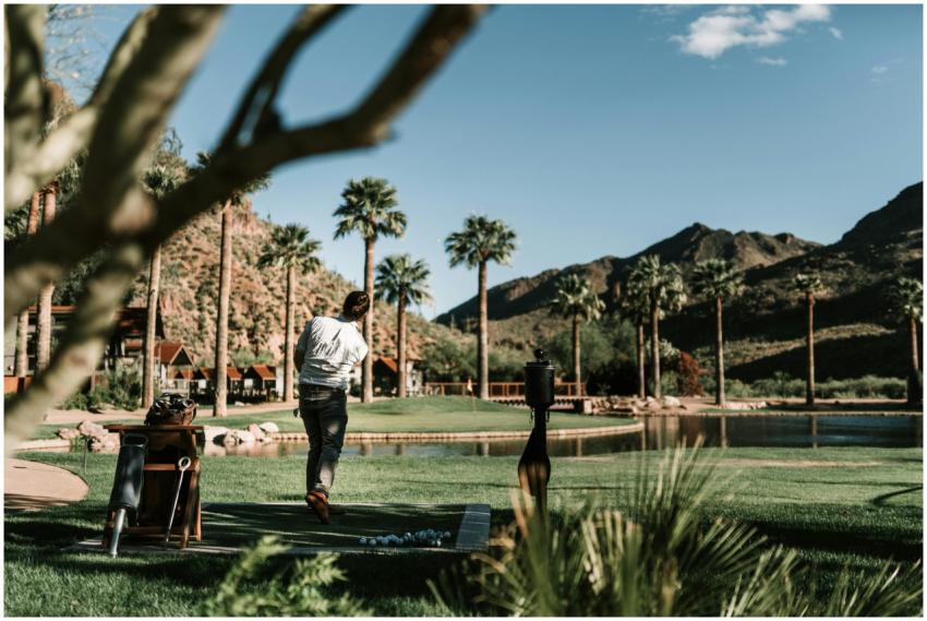 Golfer practicing swing with scenic mountain and p