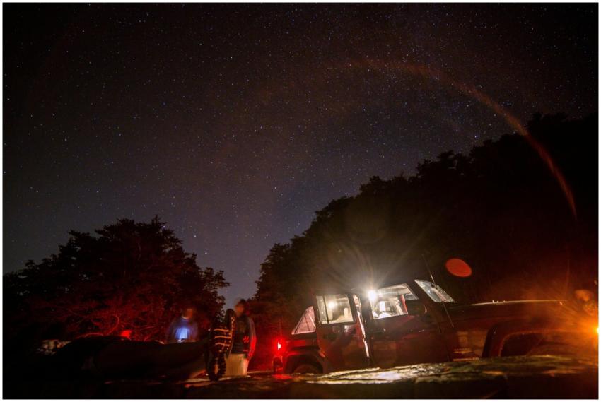Starry night camping scene with a vehicle and blur